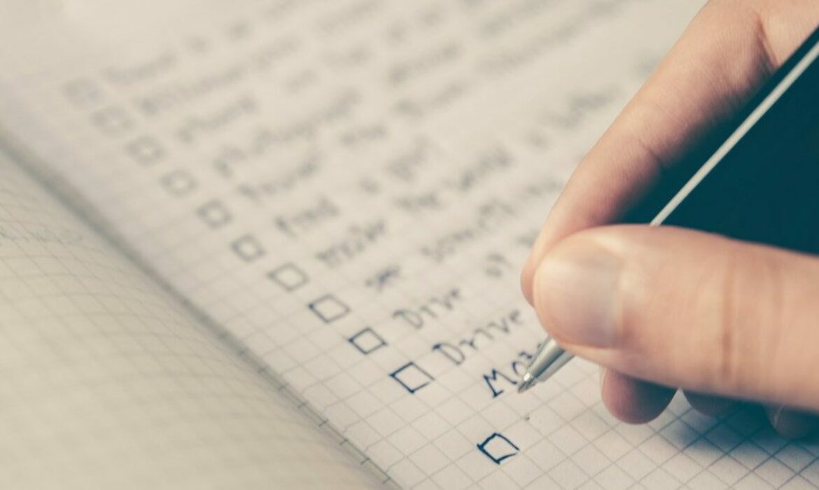 person writing bucket list on book