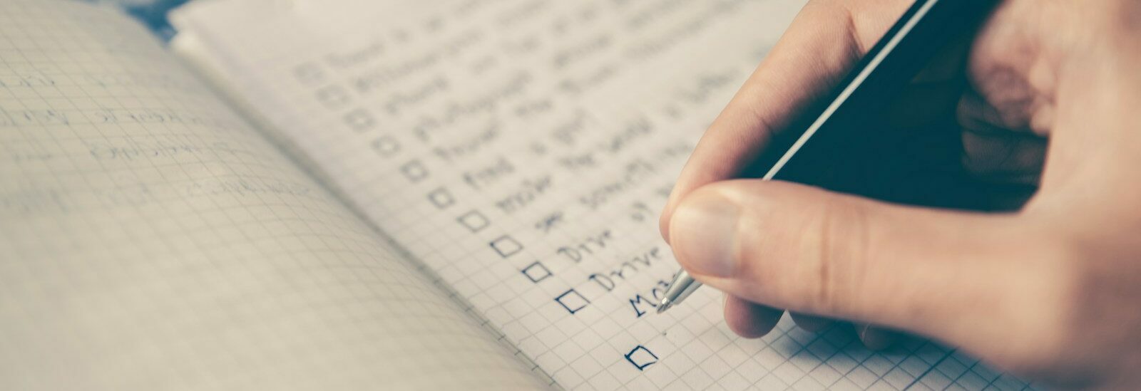 person writing bucket list on book