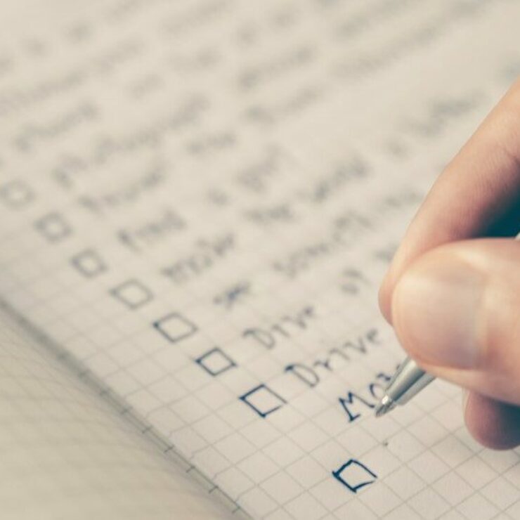 person writing bucket list on book
